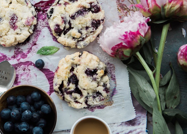 blueberry cookies beside a bowl of blueberries and flowers